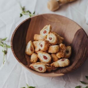 A wooden bowl filled with tasty pastries perfect for a sweet snack.
